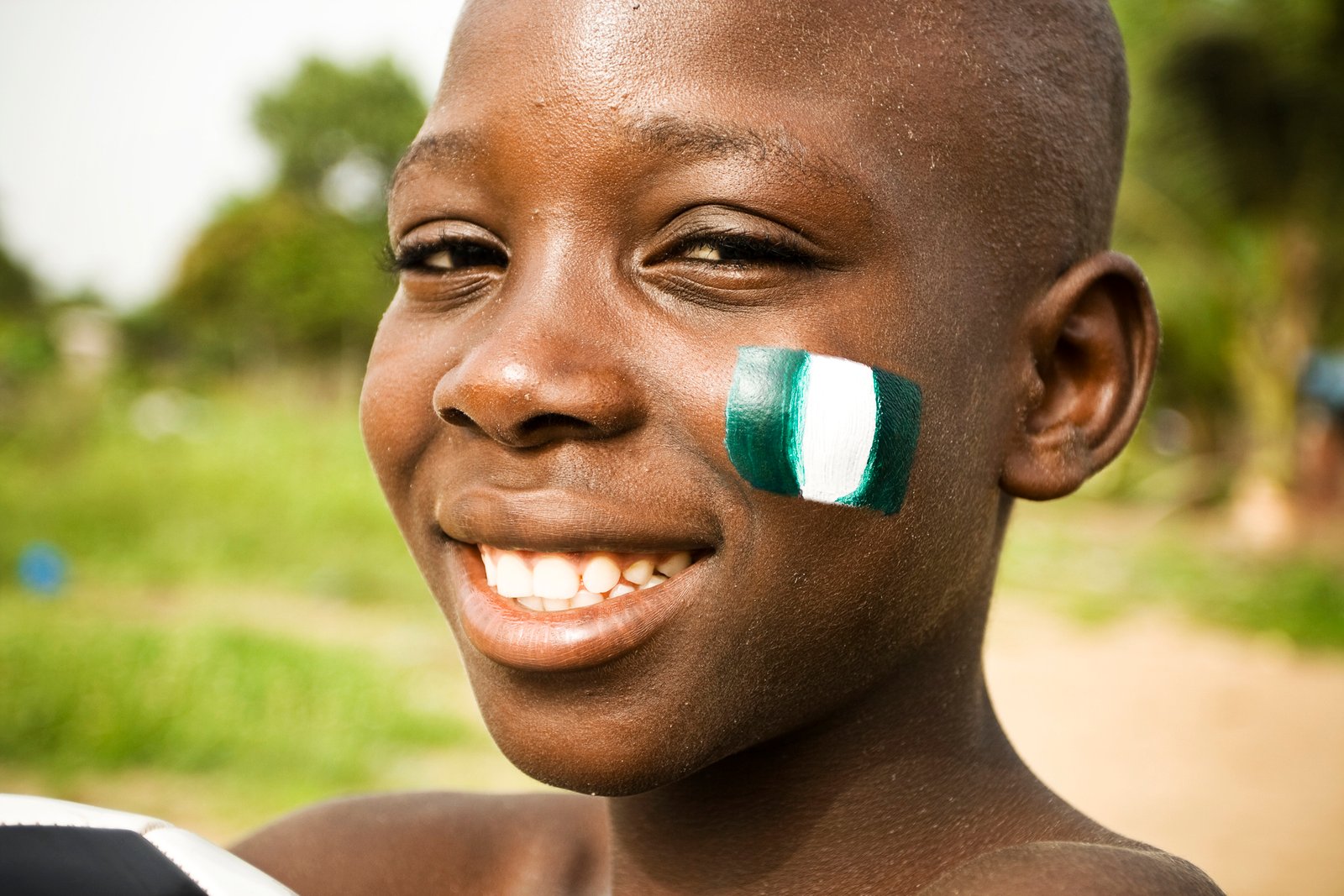 African boy with flag of Nigeria on a cheek